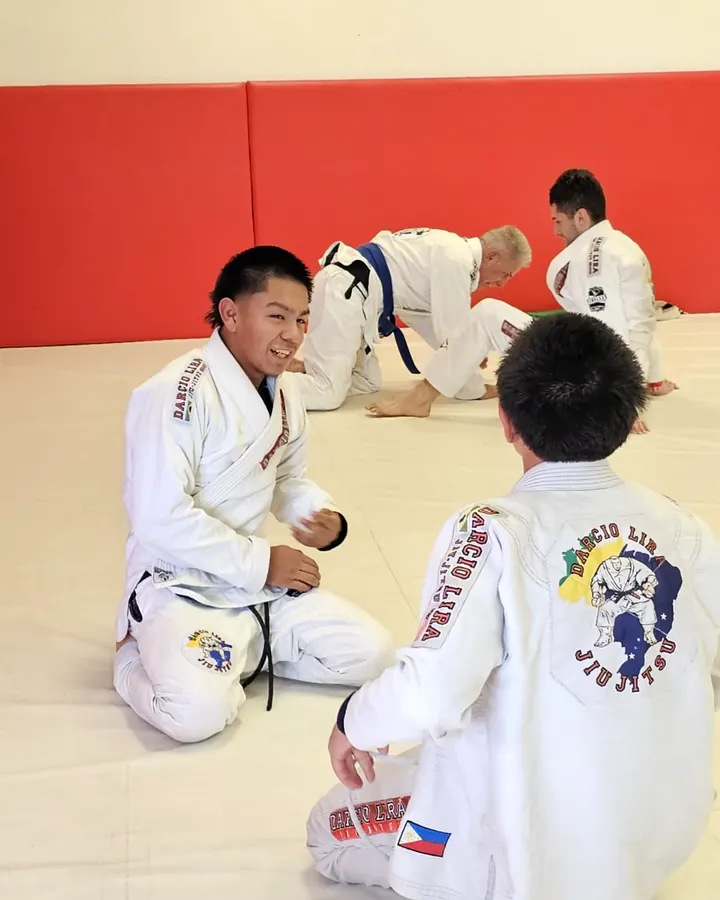 Young students kneeling calmly on the mats at Darcio Lira BJJ