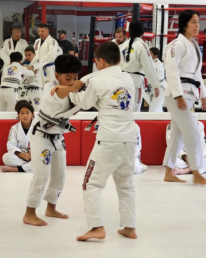 Two young students drilling with an instructor close by at Darcio Lira BJJ